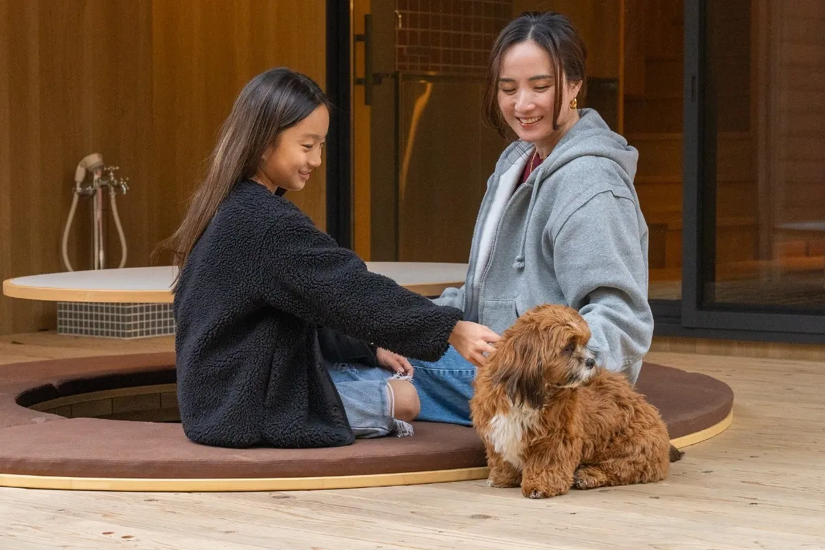 テラスで愛犬とくつろぐ家族の様子