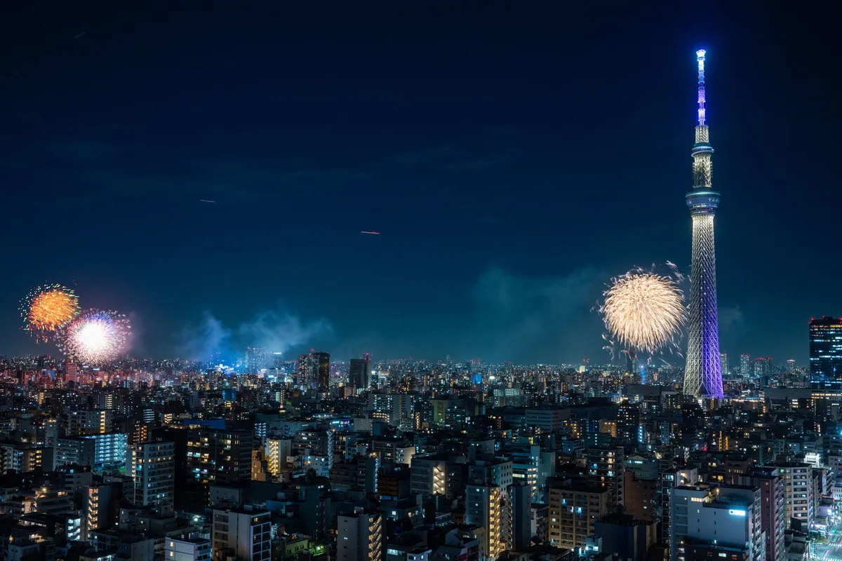 隅田川の花火とライトアップされた東京スカイツリーの共演