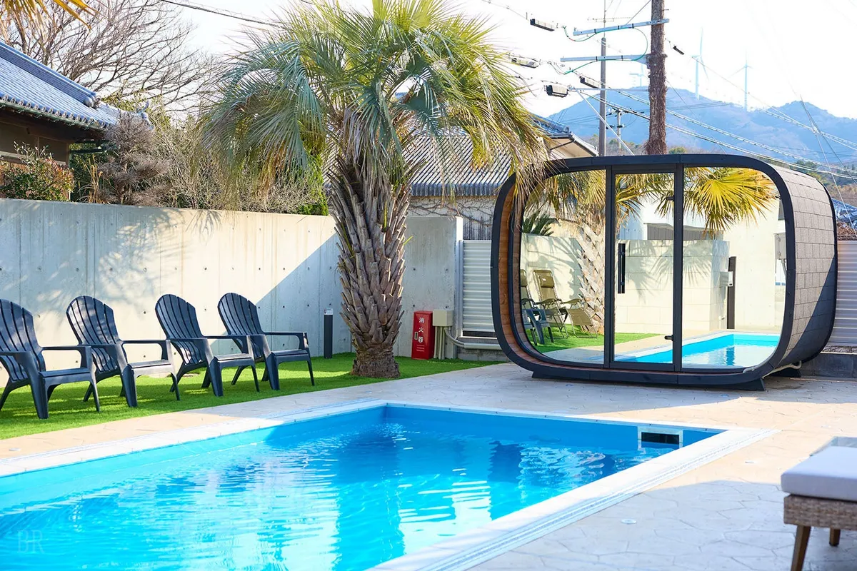 青い空と澄み渡るプール、その奥に佇むサウナポッドがリゾート感を演出しています。