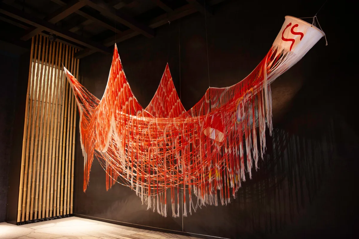 赤い糸を幾重にも垂らし、こいのぼりの形を再構築した繊細なアート作品