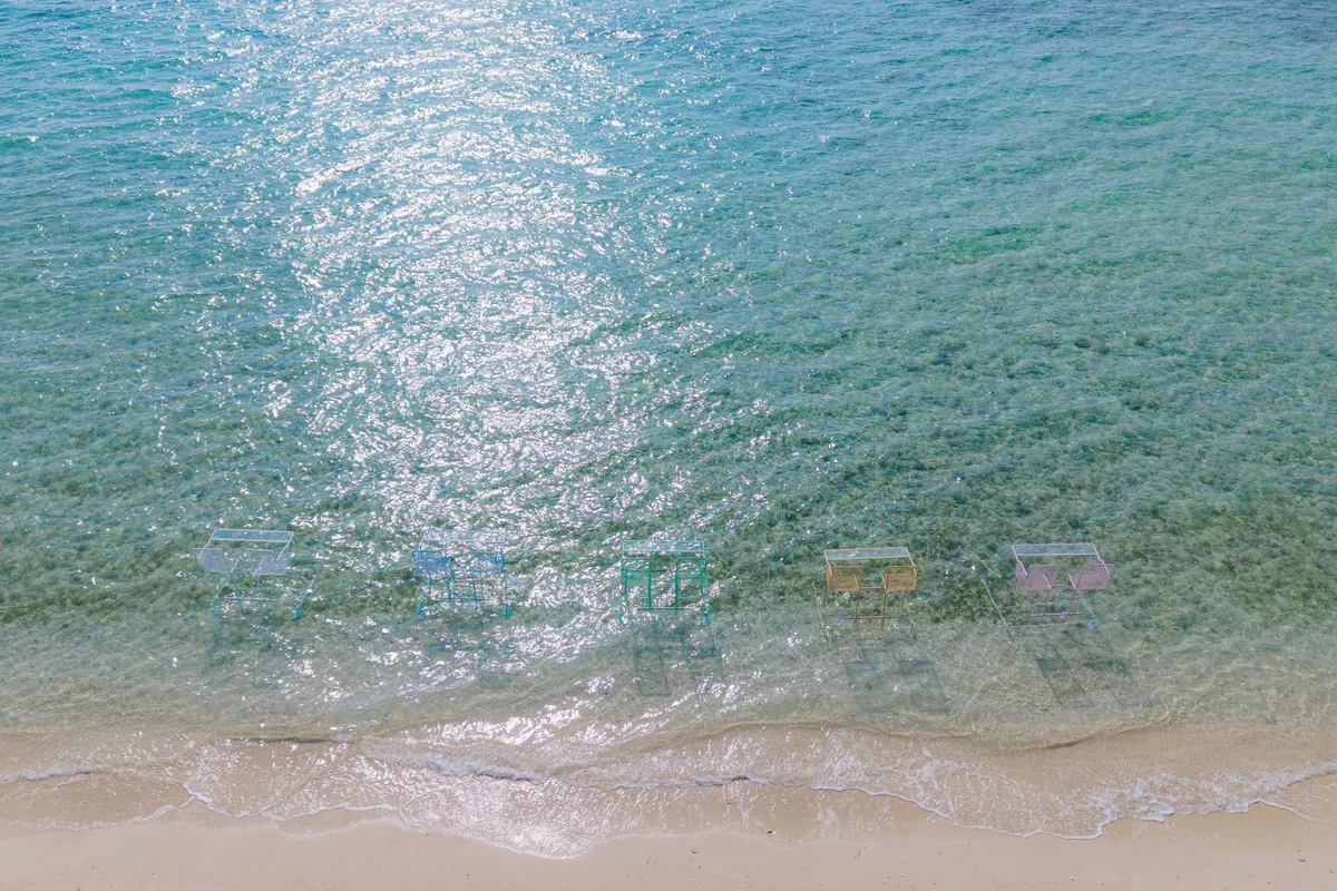 透き通る海に並ぶカラフルな海上席を上から見た様子