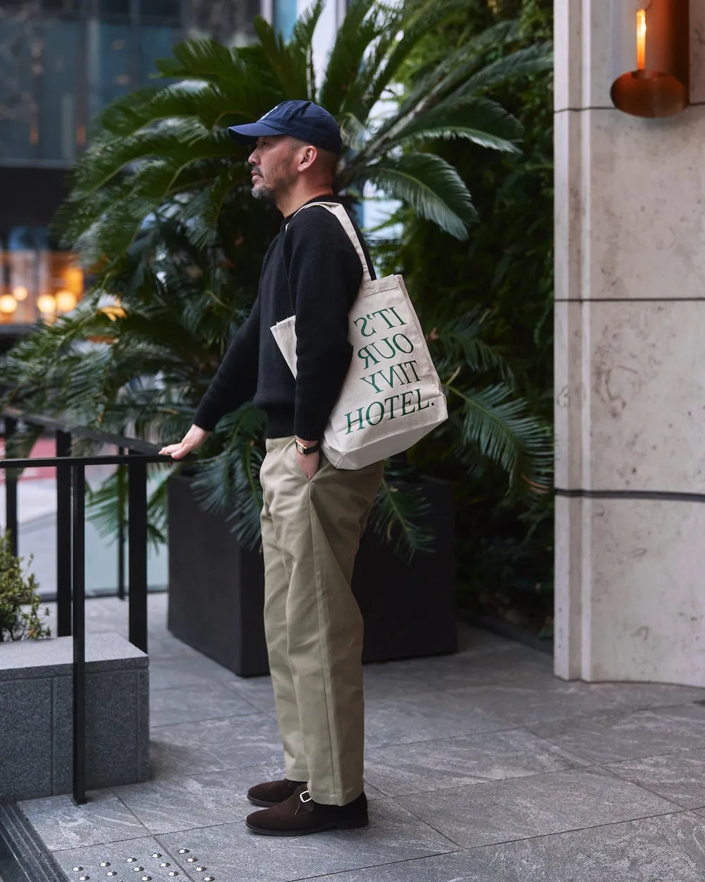 青山の街角でトートバッグを肩にかける男性のスタイリング