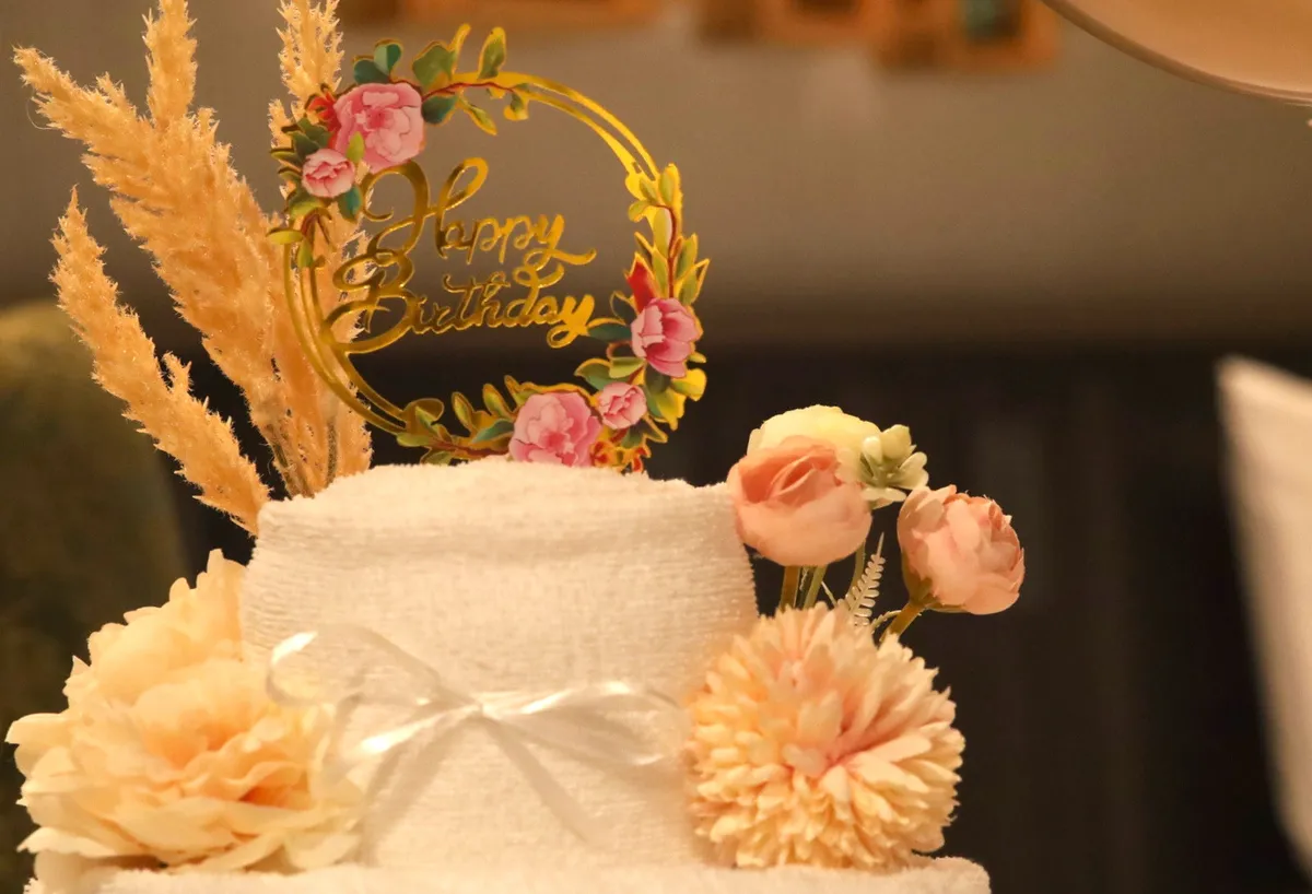 Happy Birthdayのプレートが添えられたタオルアートのケーキ