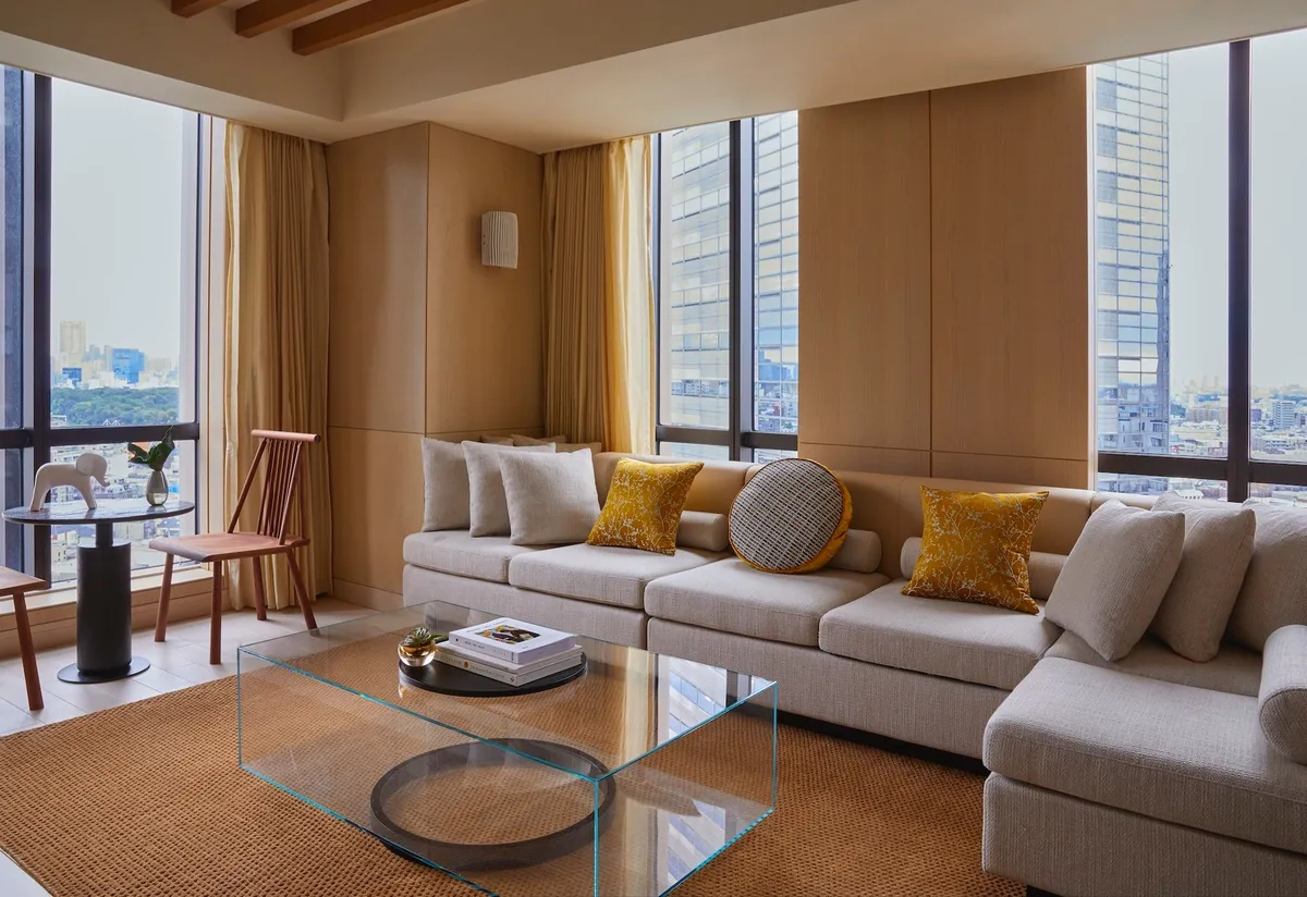 モダンな家具と柔らかな光が差し込むスイートルームの客室