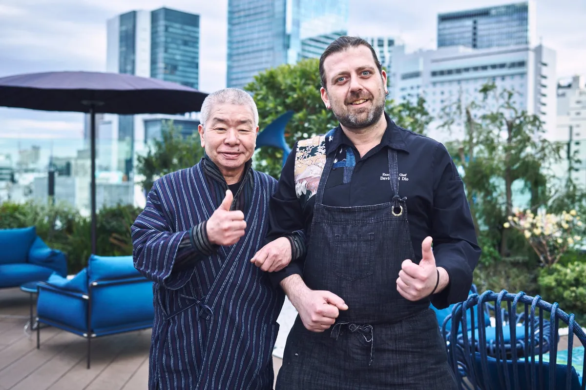 渋谷のスカイラインを背景にテラスでポーズをとる二人