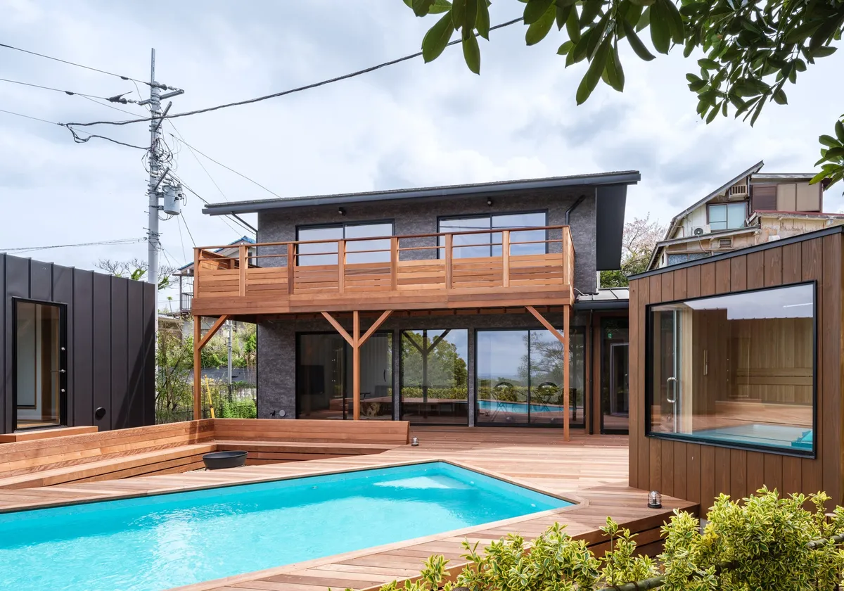 広々としたウッドデッキに設置されたプールとサウナ小屋の全景