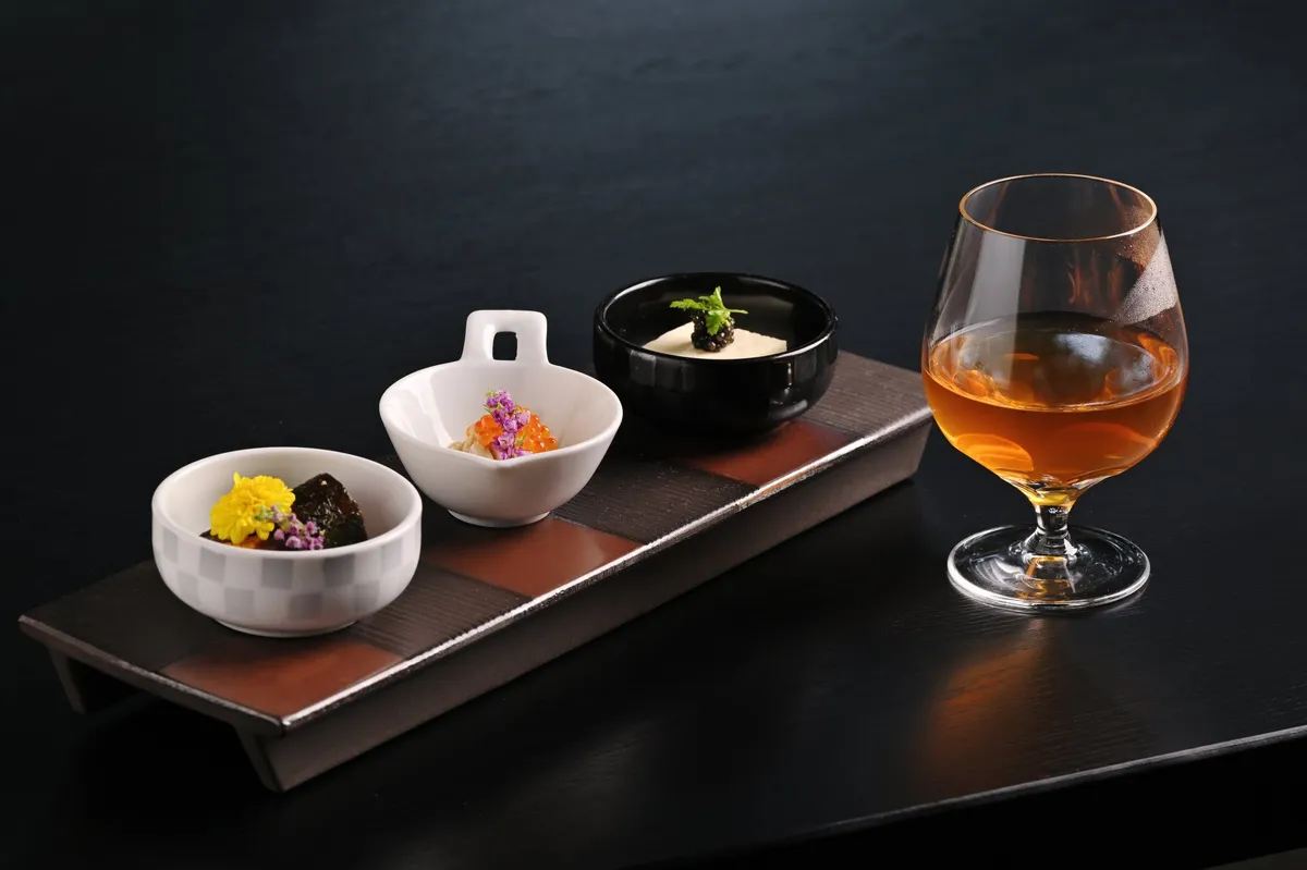 彩り豊かな3種のおつまみと琥珀色のドリンク