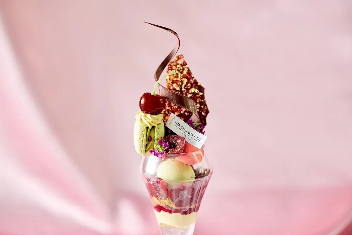 ダークチェリーとピスタチオのマカロン、チョコレートが美しく飾られたパフェのトップ部分