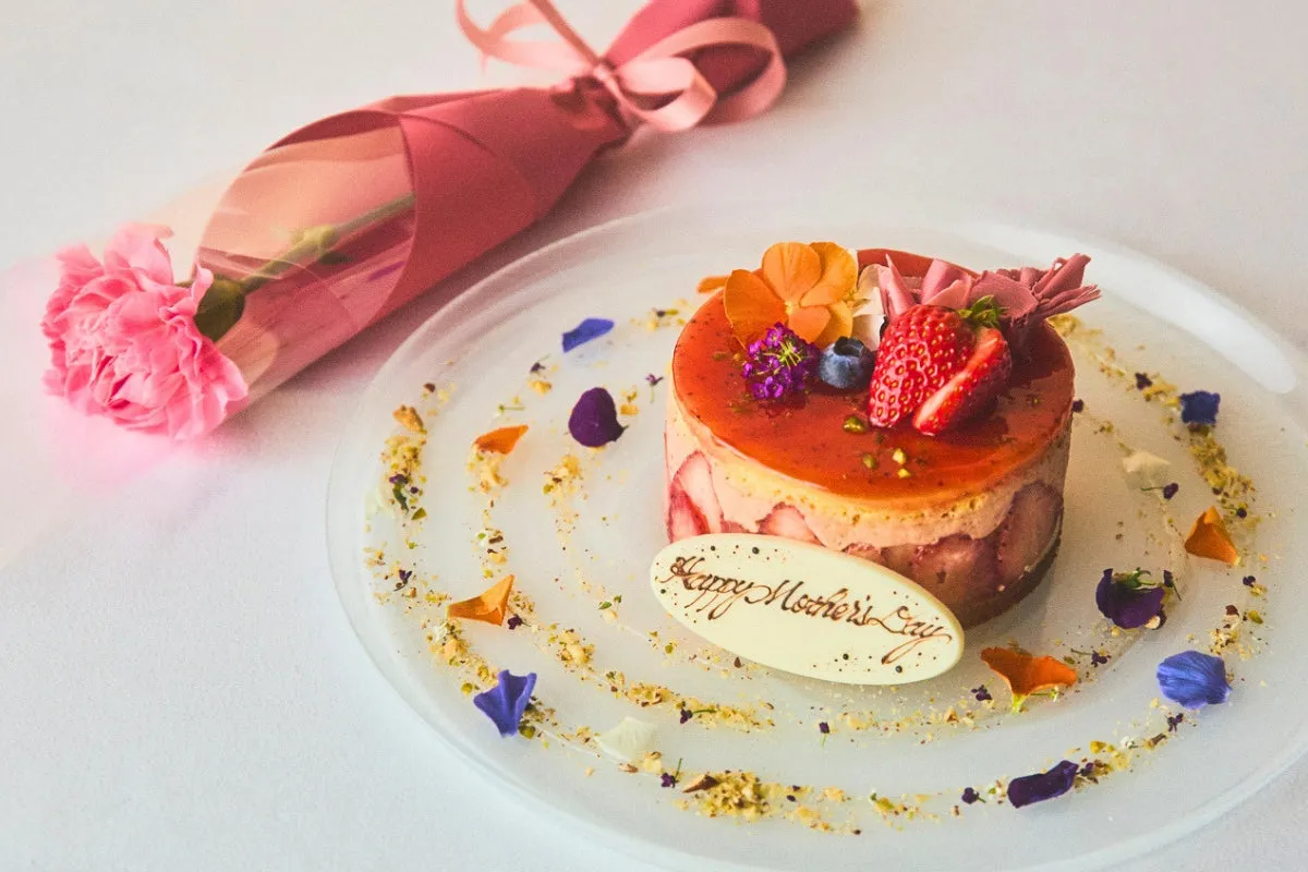 ケーキと一輪のカーネーションがセットになった母の日の贈り物イメージ。