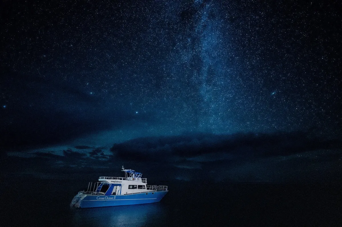 星空の下を航行するクルーズ船「Cross Ocean II」