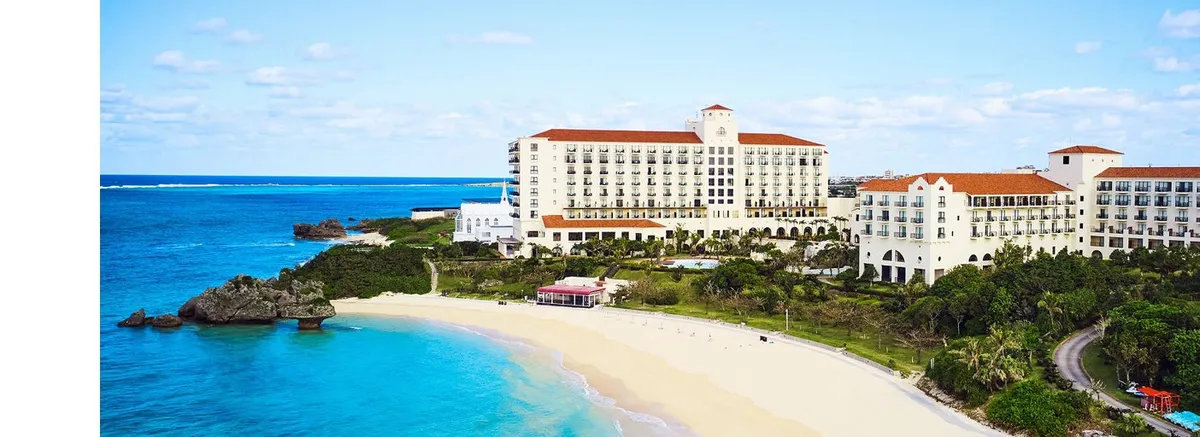 青い海と白い砂浜に映える南欧風のホテル外観