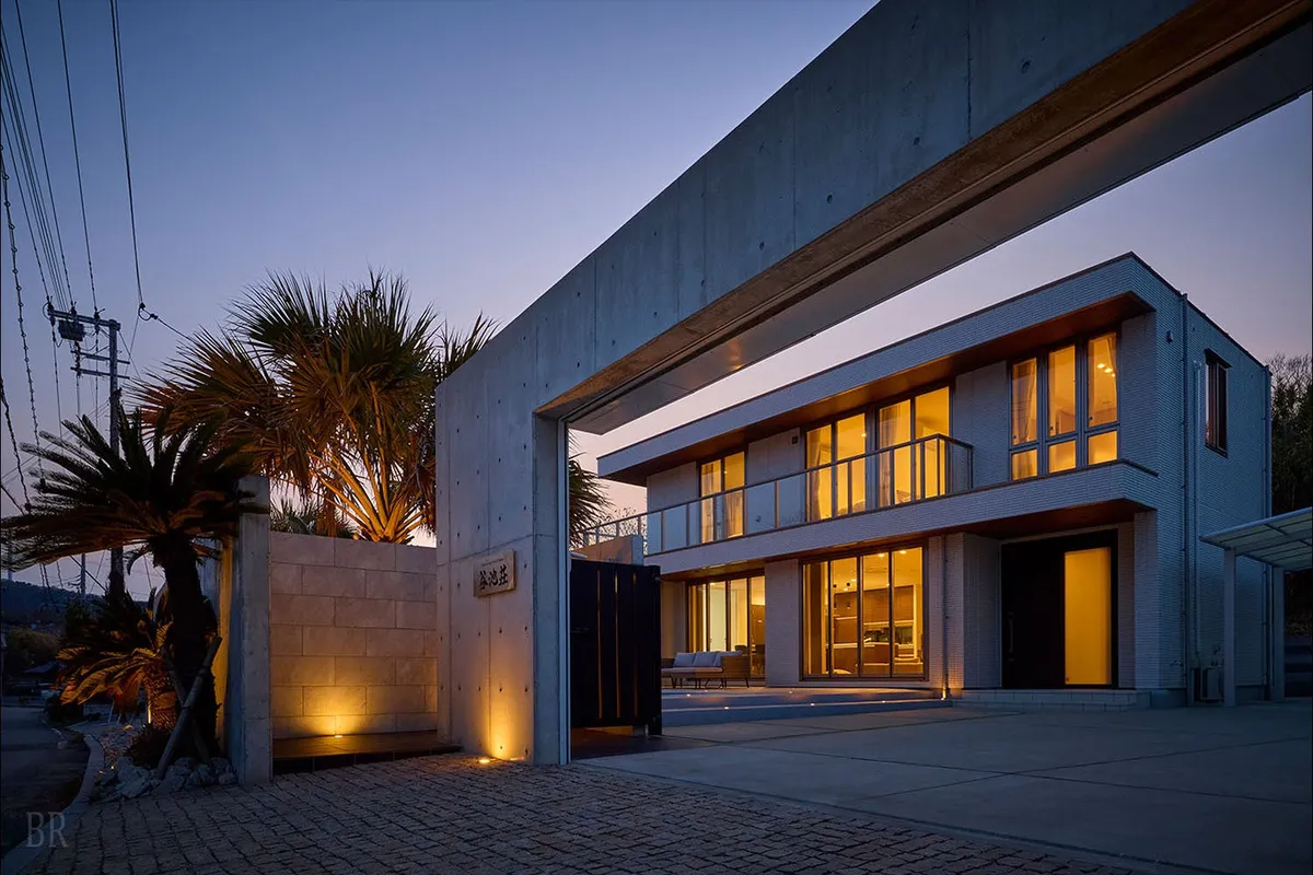 夜の帳が下りる頃、温かな光に包まれるモダンなヴィラの外観。洗練されたデザインが目を引きます。