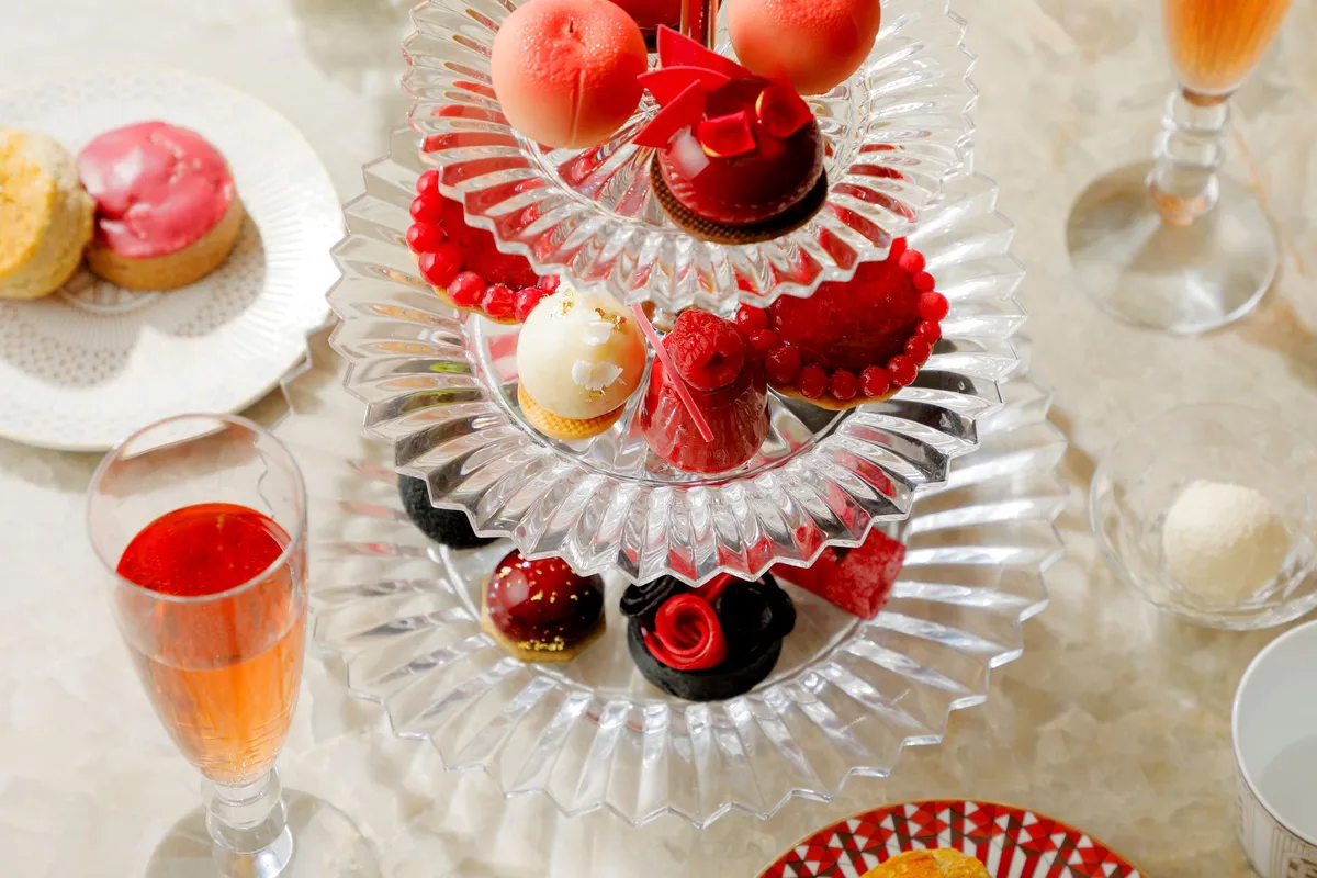3段のクリスタルスタンドに美しく並べられた桃のスイーツとセイボリー