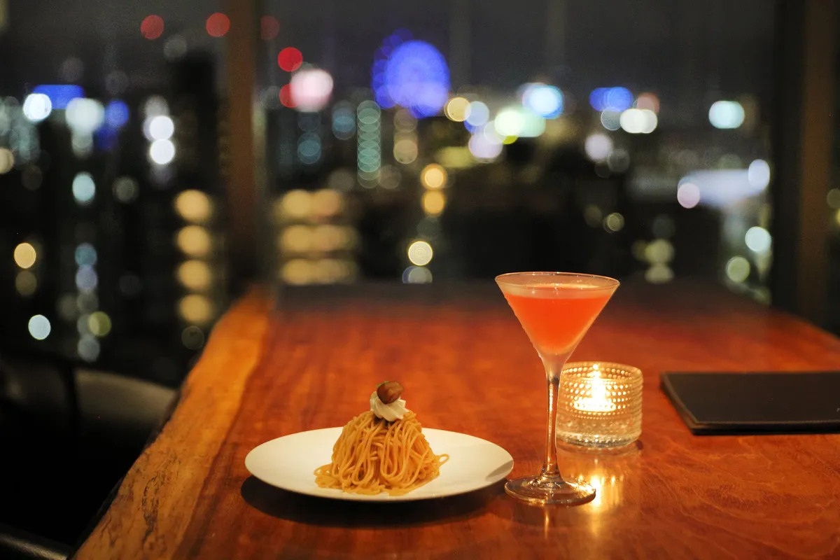 夜景を背景にしたモンブランとカクテル
