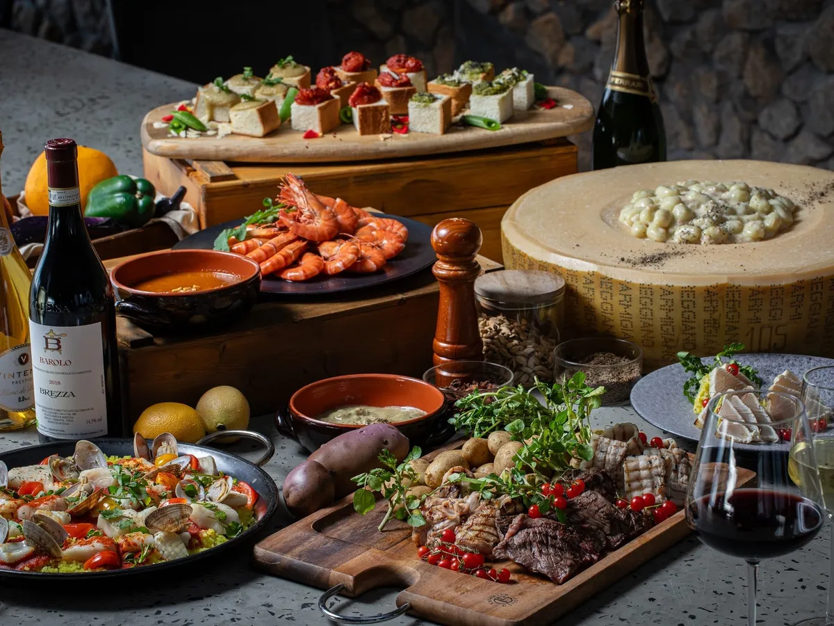 大皿に盛られたBBQ料理やパエリア、チーズの器で仕上げるパスタなどの豪華な料理