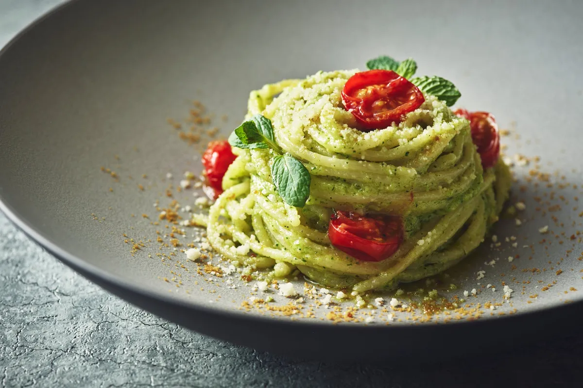 色鮮やかなトマトとミントが添えられた、シェフ特製の本格的なパスタ料理