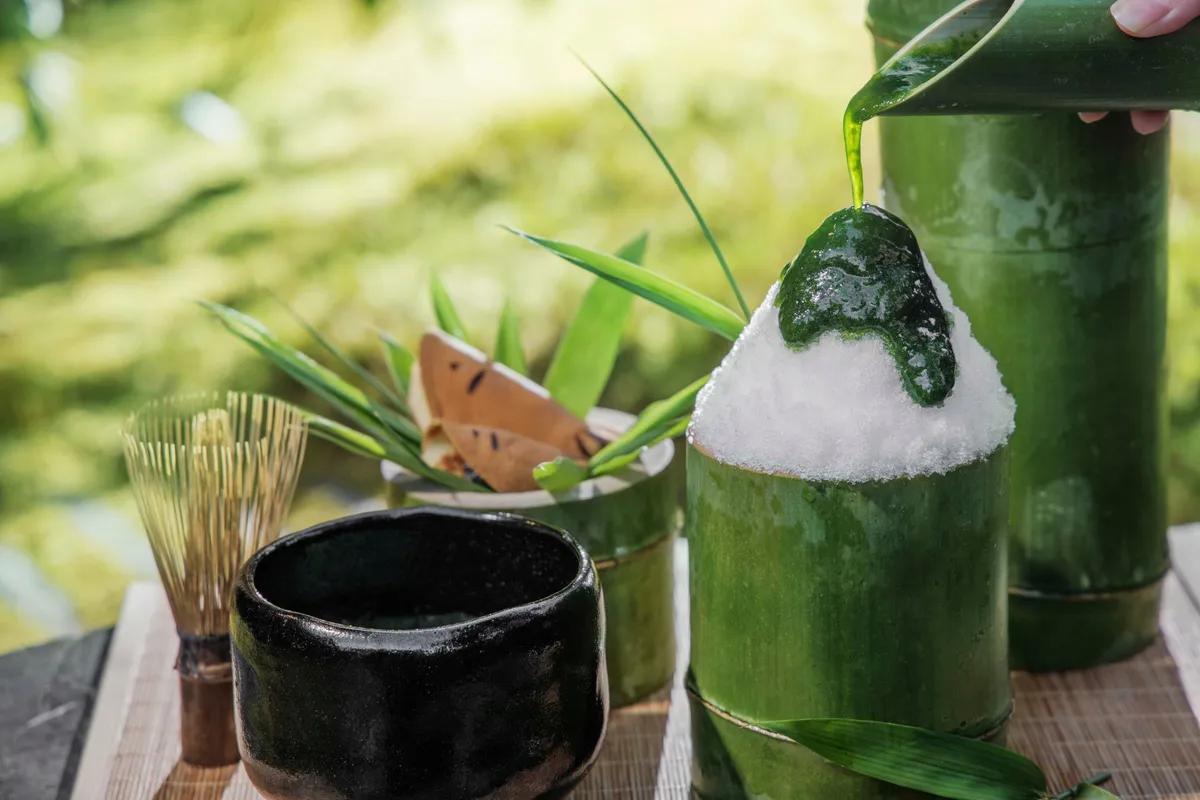 真っ白なかき氷に爽やかな緑色の蓼シロップをかける様子