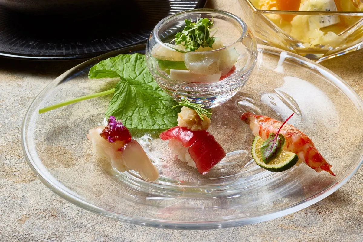 透明なプレートに美しく配されたお造りと寿司