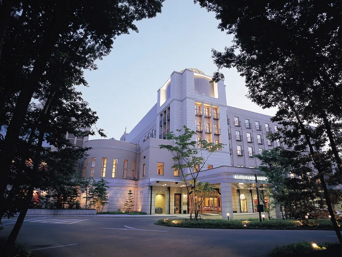 夜の森に美しくライトアップされた水戸プラザホテルの外観