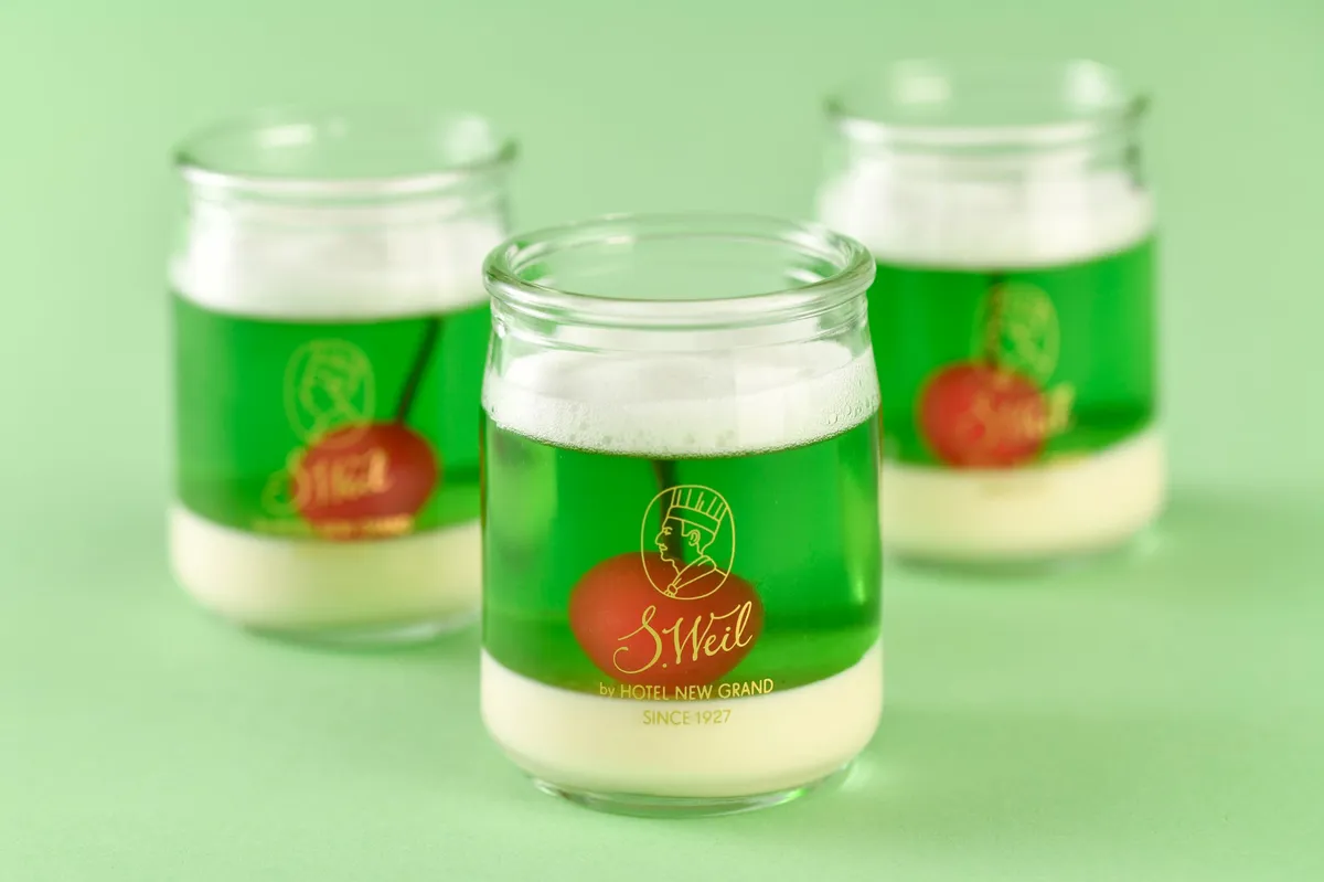 鮮やかな緑色のゼリーの中にさくらんぼが入ったクリームソーダゼリー。