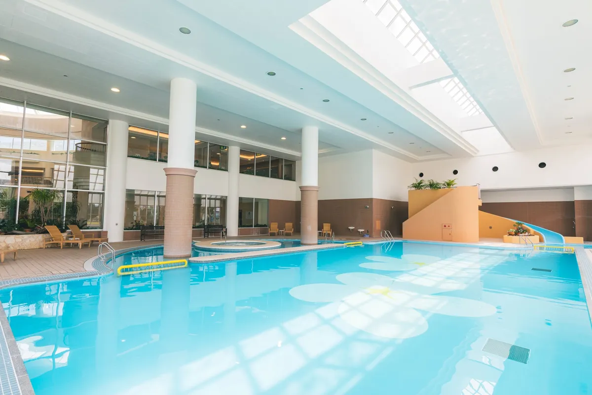 高い天井と自然光が差し込む広々とした屋内プール