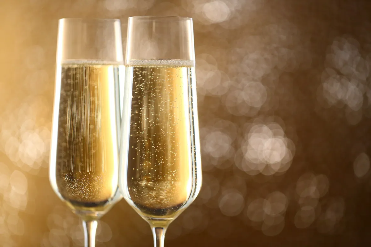 黄金色に輝くスパークリングワインが注がれた、二つのシャンパングラス