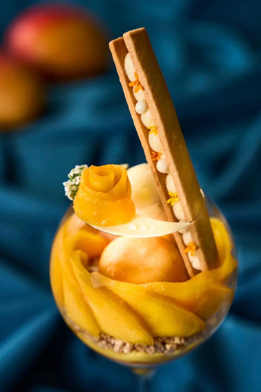 マンゴーのスライスを薔薇の花のように仕立てた繊細なデコレーション