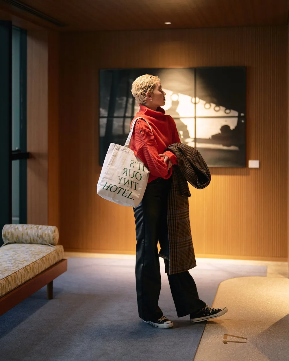 ホテルの洗練されたインテリアの中でトートバッグを持つ女性