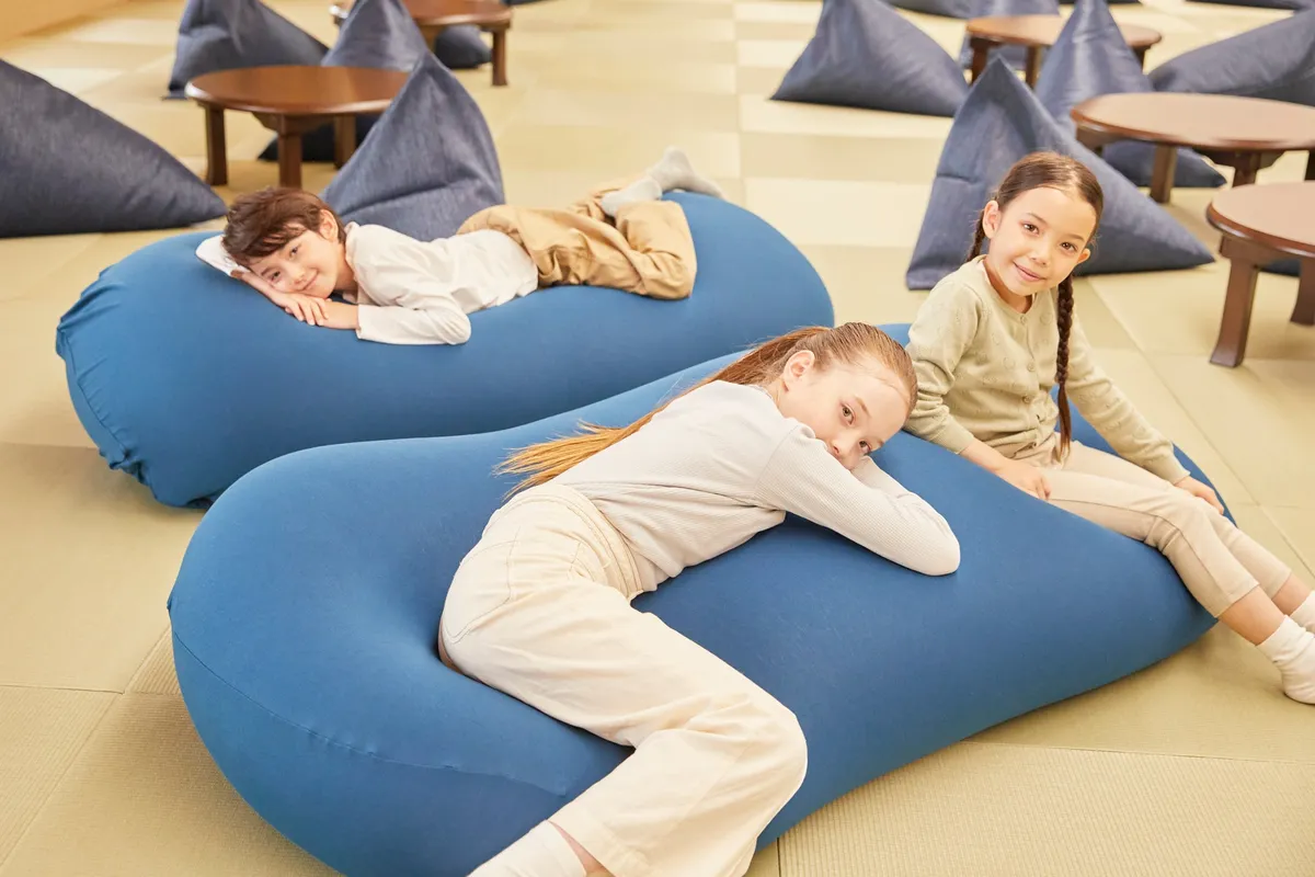 青いクッションでくつろぐ子供たち