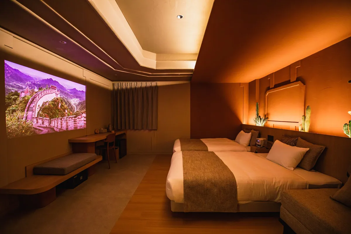 落ち着いた照明のツインルームに投影された美しい風景映像