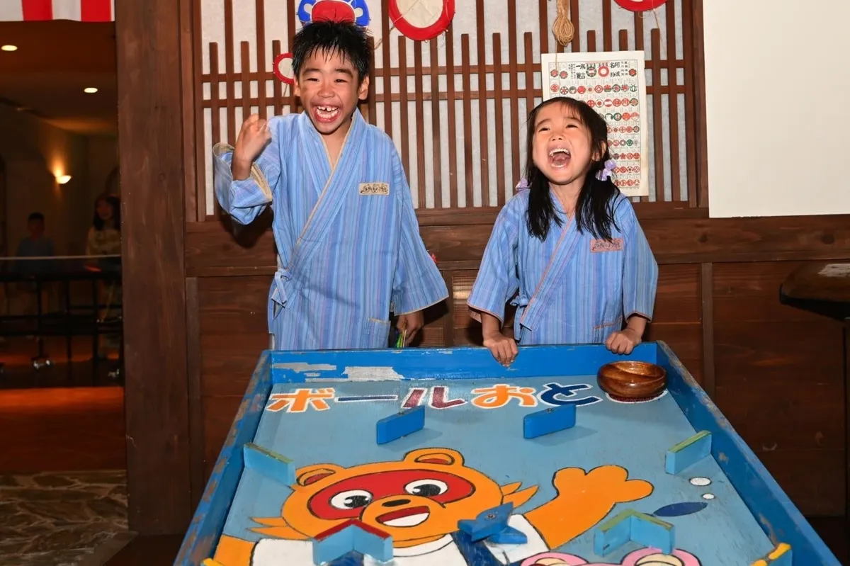 縁日で「たぬきのお金」を使って遊ぶ子供たち