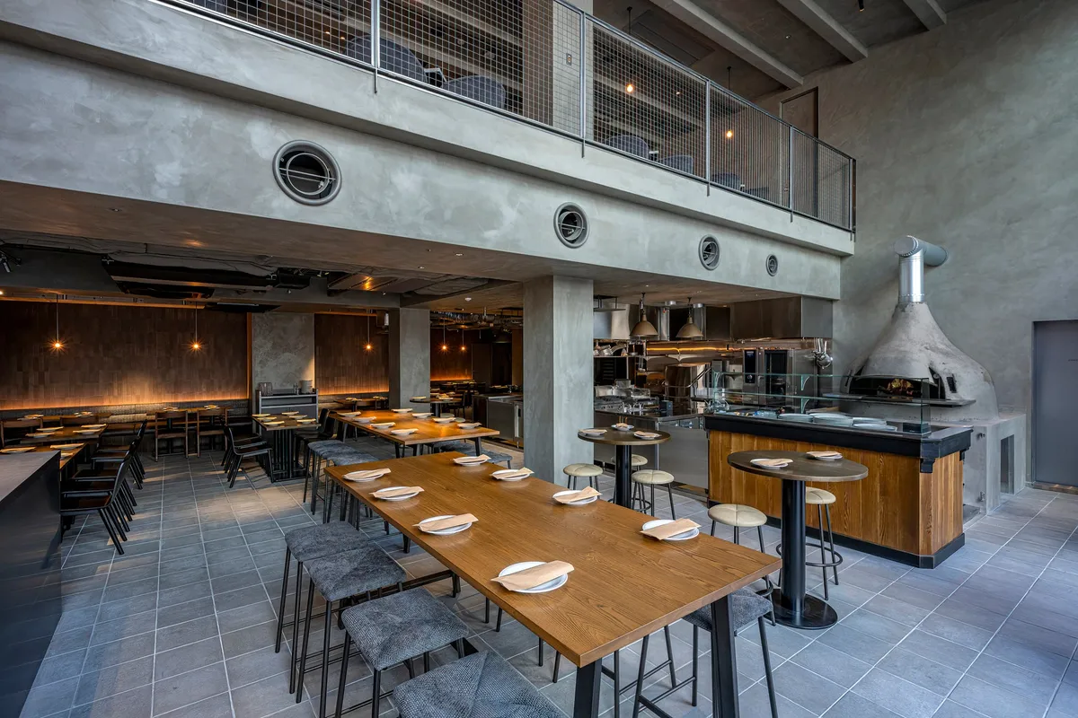 高い天井と薪窯が印象的な開放感あふれるレストラン内観