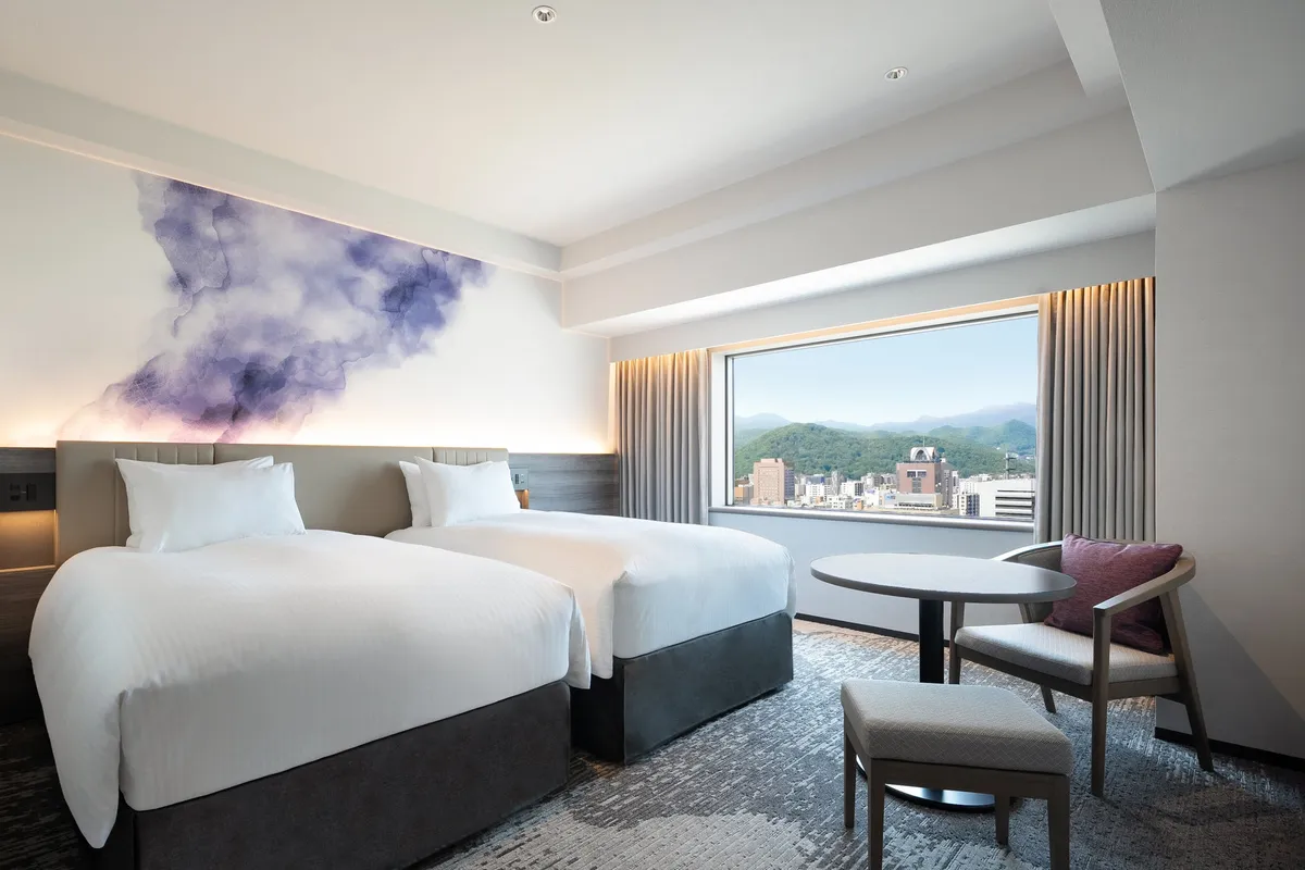 壁面に施されたアートと大きな窓からの眺望が美しいモダンな客室