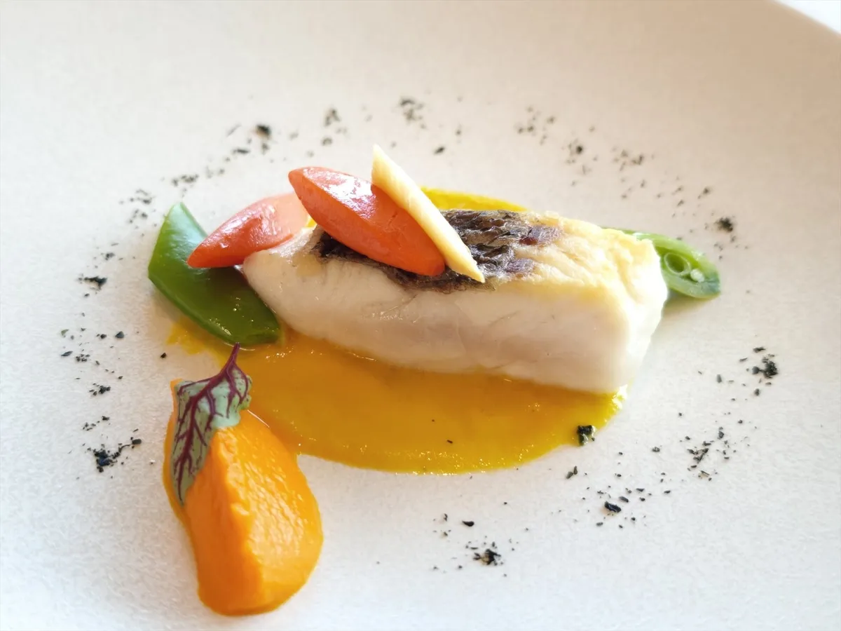 春にんじんのピューレを添えた繊細な魚料理