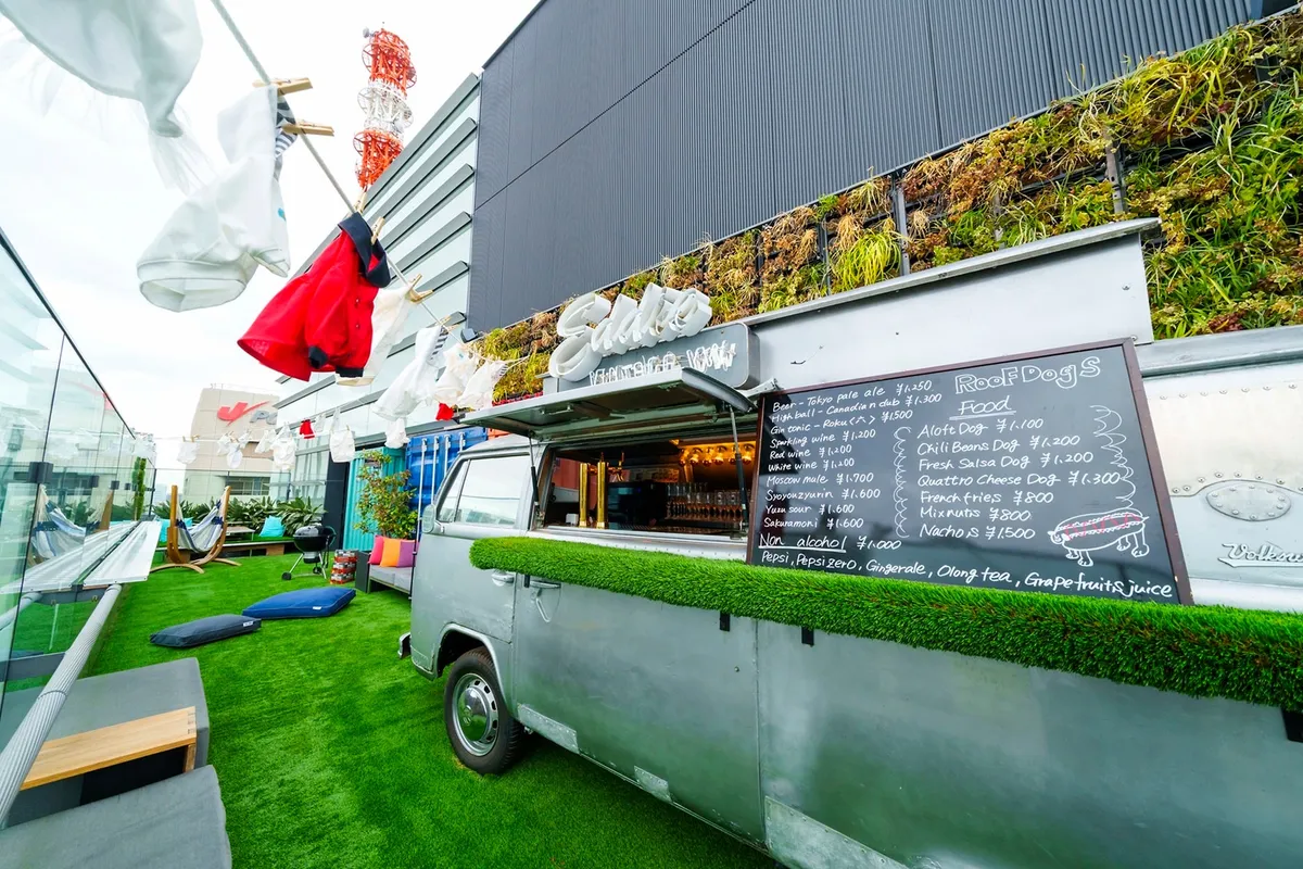 ルーフトップバー「Roof Dogs」の象徴的なVWバスとメニューボード