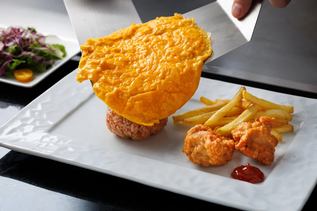 シェフが目の前でオムライスの卵を仕上げる様子