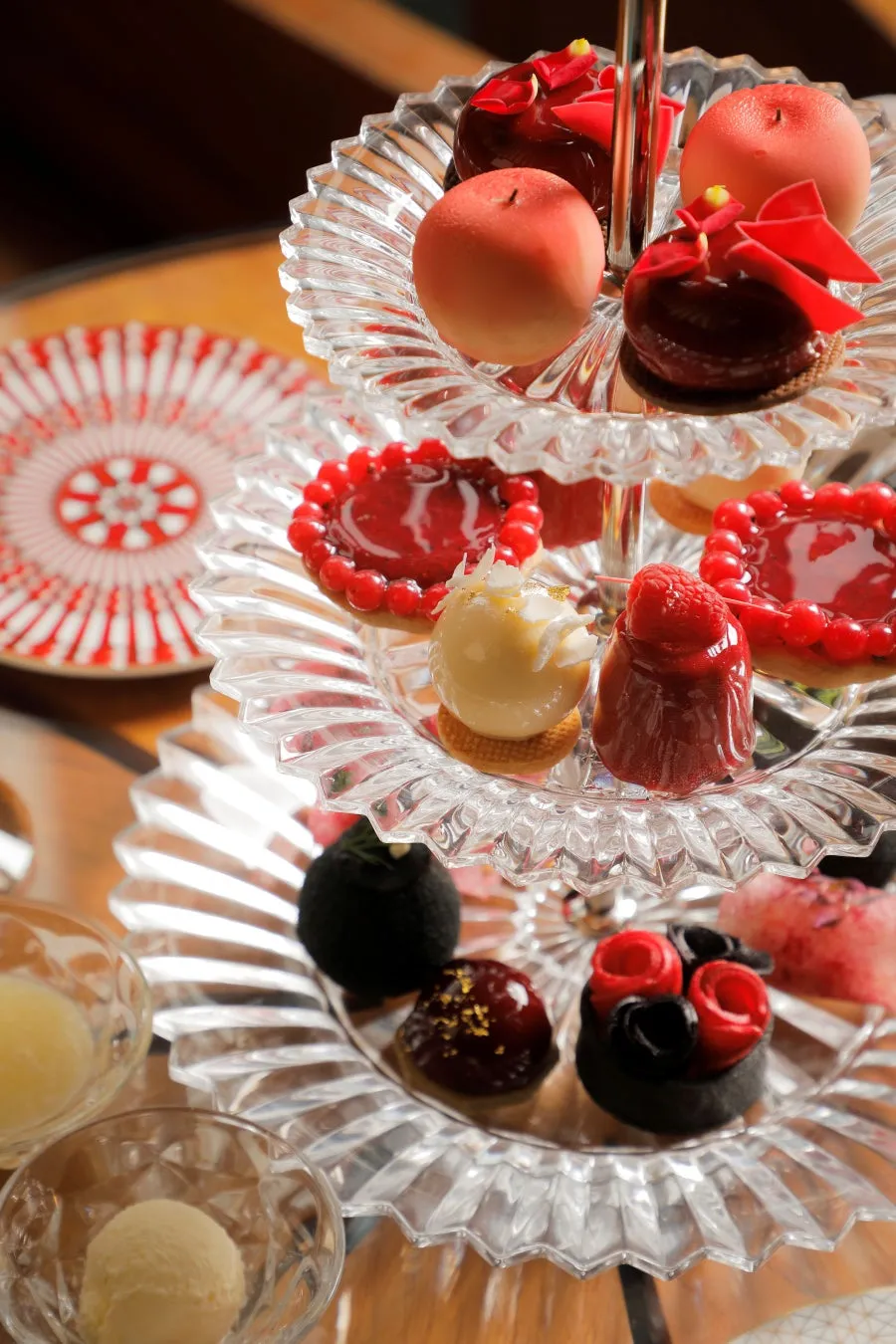 バカラの赤いグラスと桃のアフタヌーンティーの華やかなテーブルコーディネート