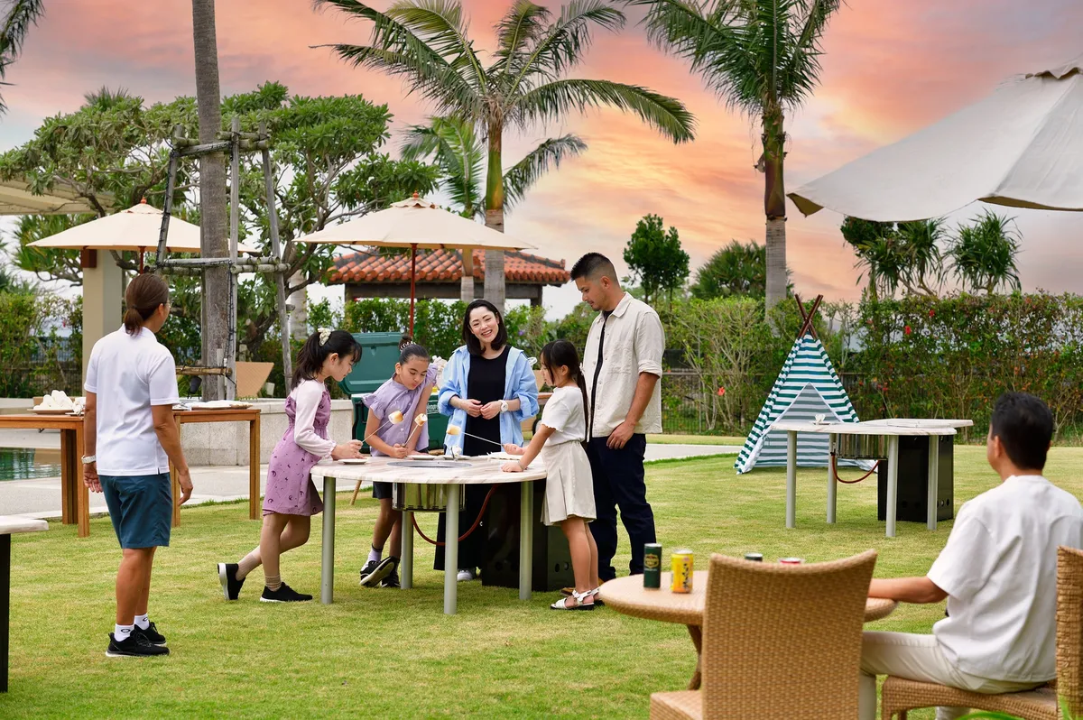 夕暮れの芝生広場でアペリティフを楽しむ家族