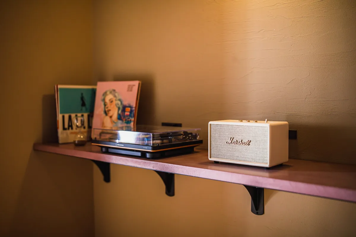 Marshallのスピーカーとレコードプレーヤーが並ぶラウンジの棚