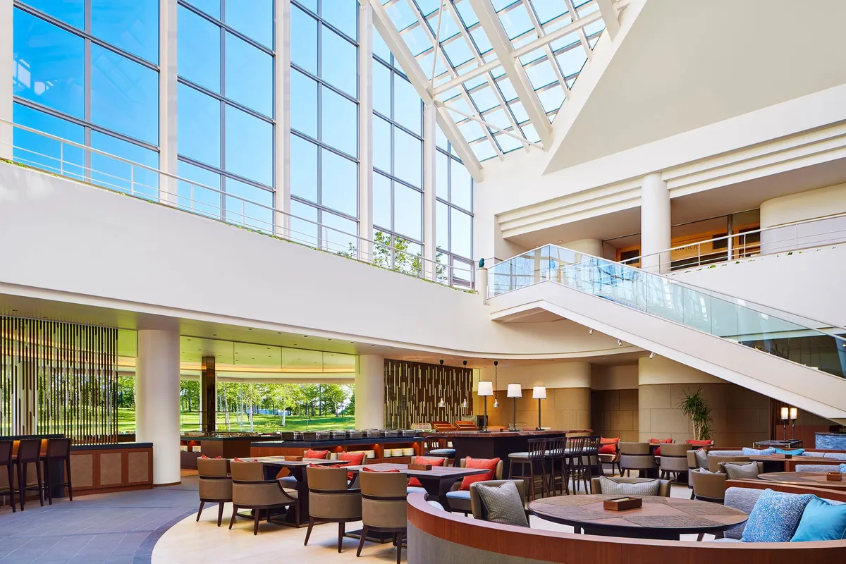 高い天井と大きな窓が特徴的なホテルのアトリウムラウンジ