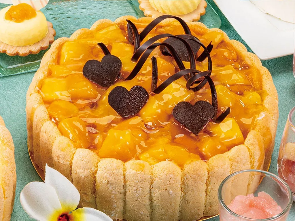 ハートのチョコが添えられた濃厚なマンゴーのケーキ