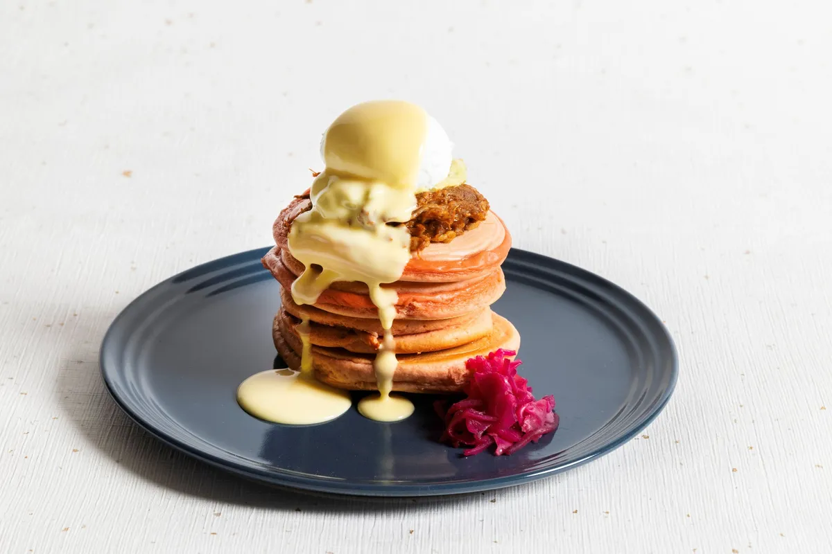 厚みのあるパンケーキにポーチドエッグとソースが絡むプルドポークベネディクト