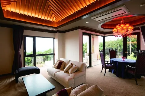 高い天井とシャンデリア、開放的な窓が特徴の最上階客室