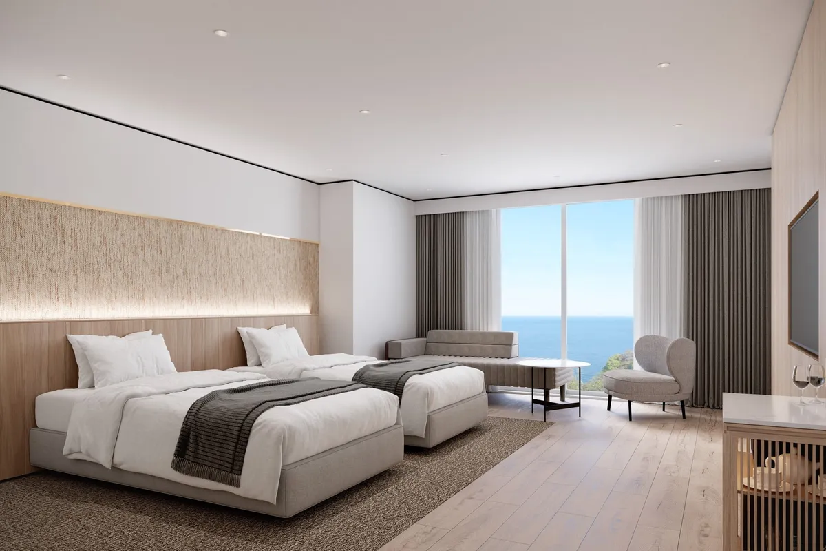 海を一望できるバルコニーを備えたモダンで清潔感のある客室