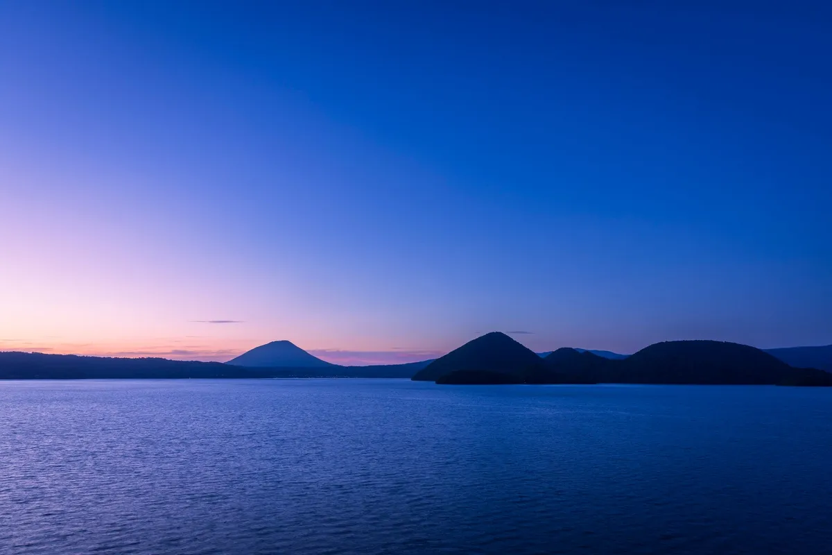 藍色に染まる洞爺湖の夕暮れ時の風景