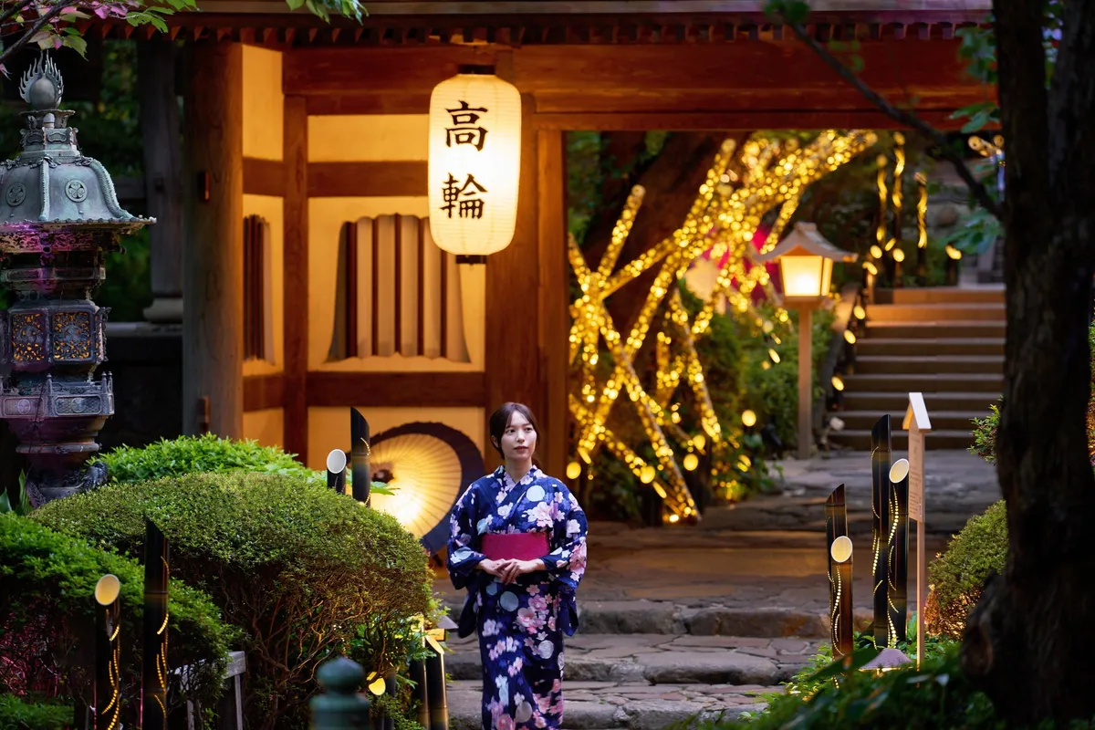 竹あかりが灯る幻想的な日本庭園と浴衣姿の女性