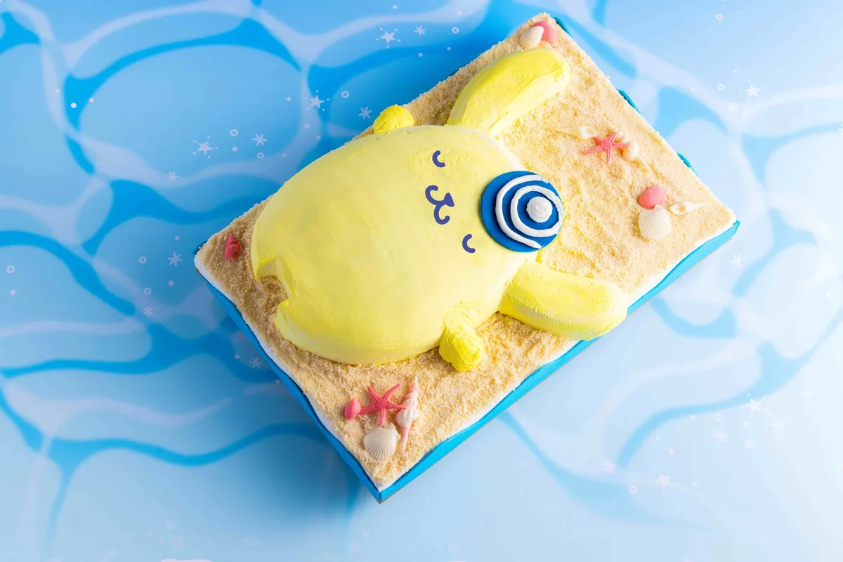 砂浜で気持ちよさそうにお昼寝するポムポムプリンの立体的なケーキ