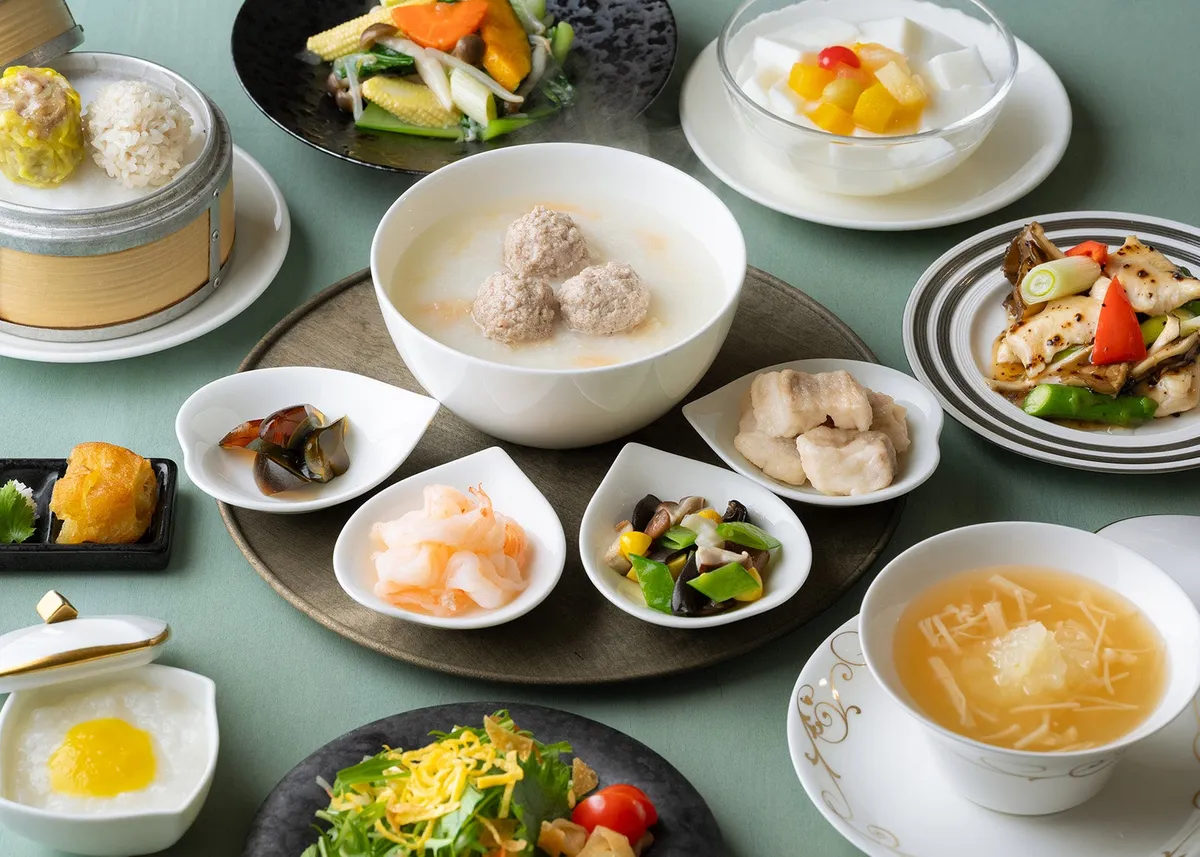 大きな肉団子が入ったお粥と、数種類の小皿料理が並ぶランチコース