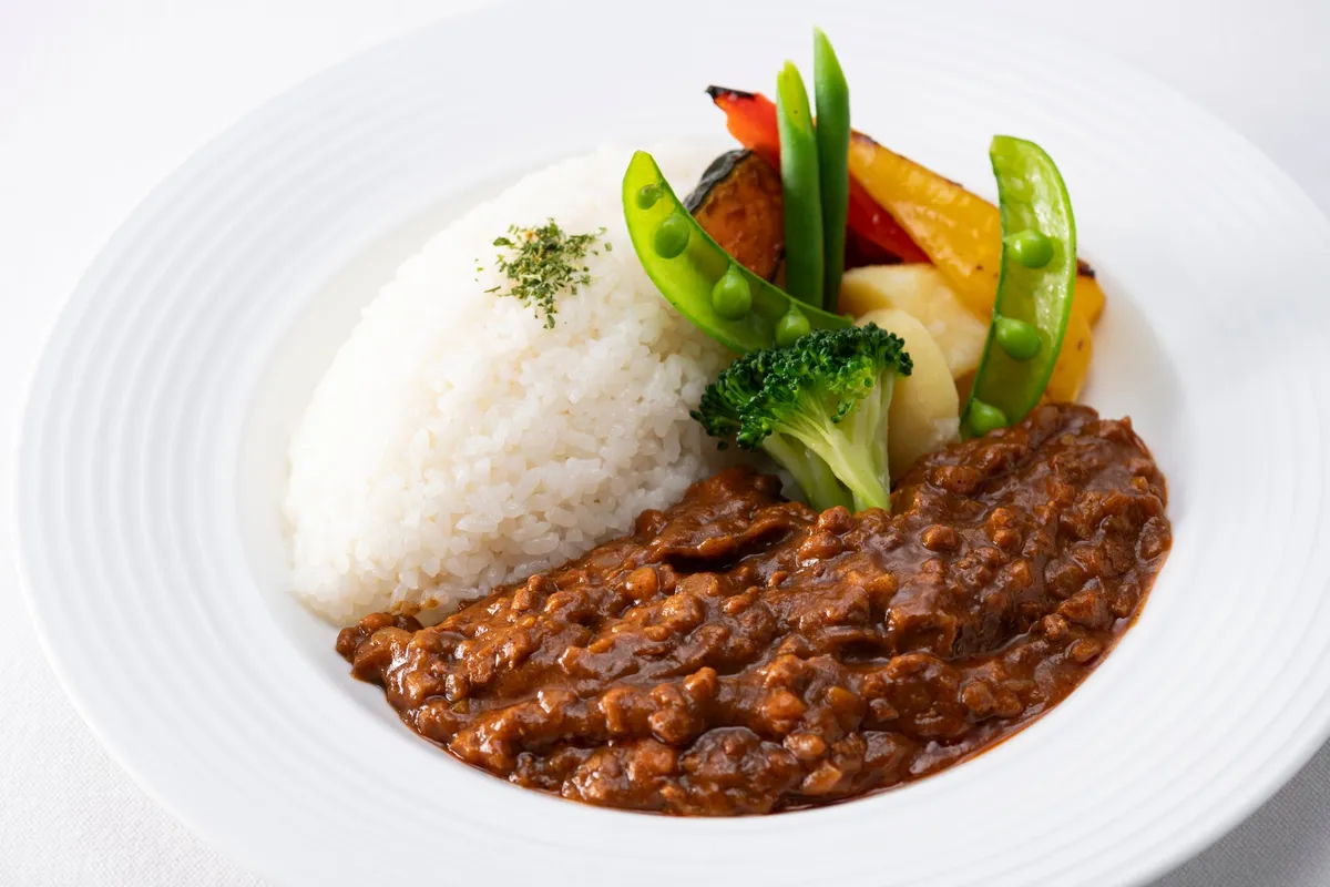 彩り豊かな野菜が添えられた大豆ミートのプラントベースカレー