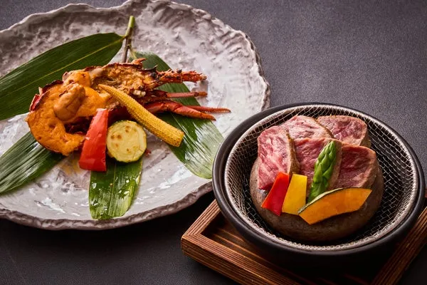 メイン料理の選択肢であるイセエビの鬼殻焼きと石焼き国産牛サーロインの比較